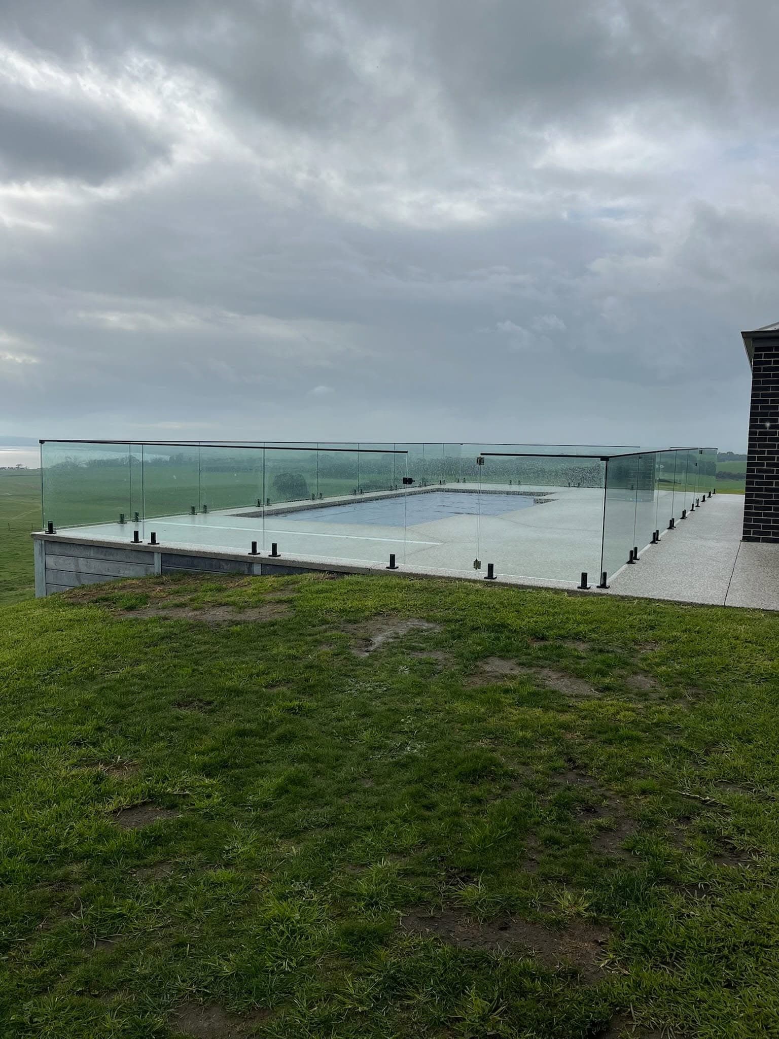 Pool with frameless glass fencing overlooking the coast