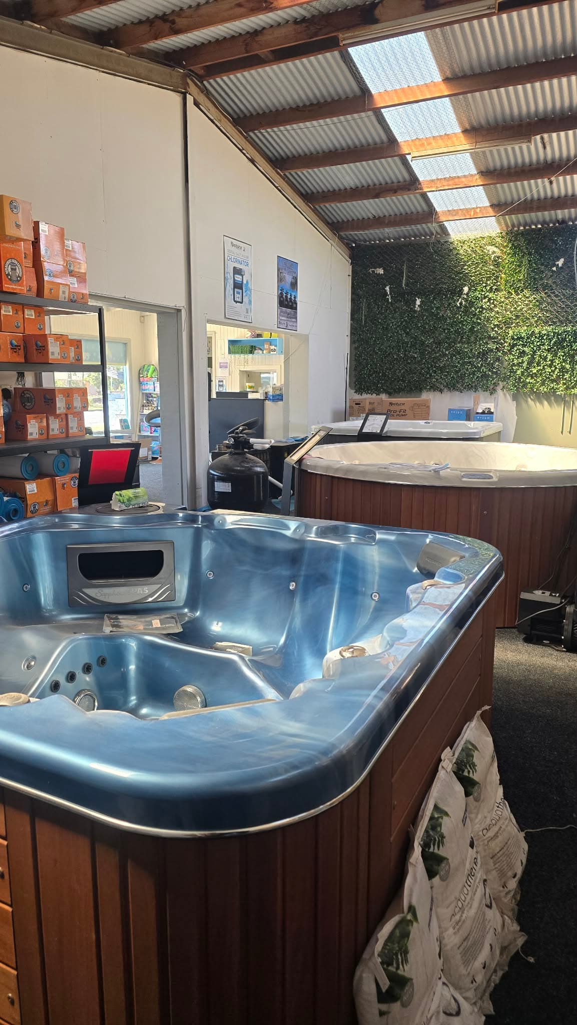 A blue spa on display in the Pristine Pools showroom, with more spas behind it